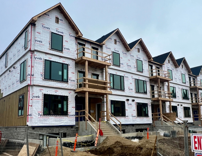 Block D windows installed. Stone masonry complete with insulation and siding underway